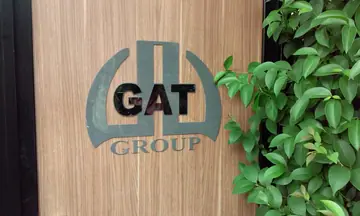 GAT Group kapı logosu — Ahşap giriş yüzeyindeki logo ve harflerin yakın görünümü.